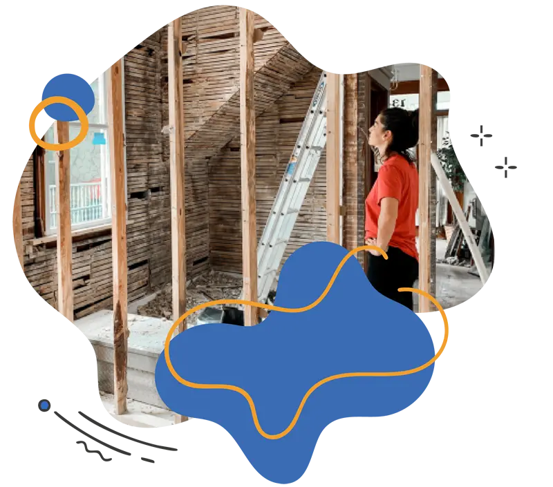Woman in a red shirt observing a partially constructed room with wooden beams and a ladder, illustrating the self-building process for modern energy-efficient homes.