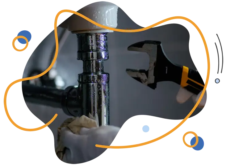 Plumber using an adjustable wrench on a shiny chrome pipe under a sink, with a focus on plumbing maintenance and installation services.